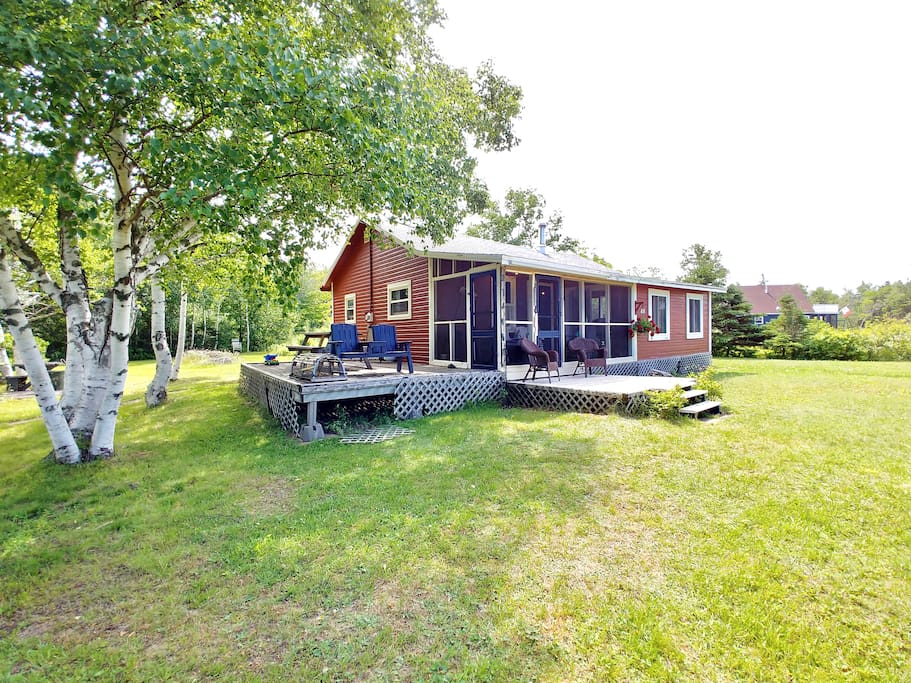 Front of the cottage with two decks and a screened in porch. Lovely trees surrounding .5 acre property.