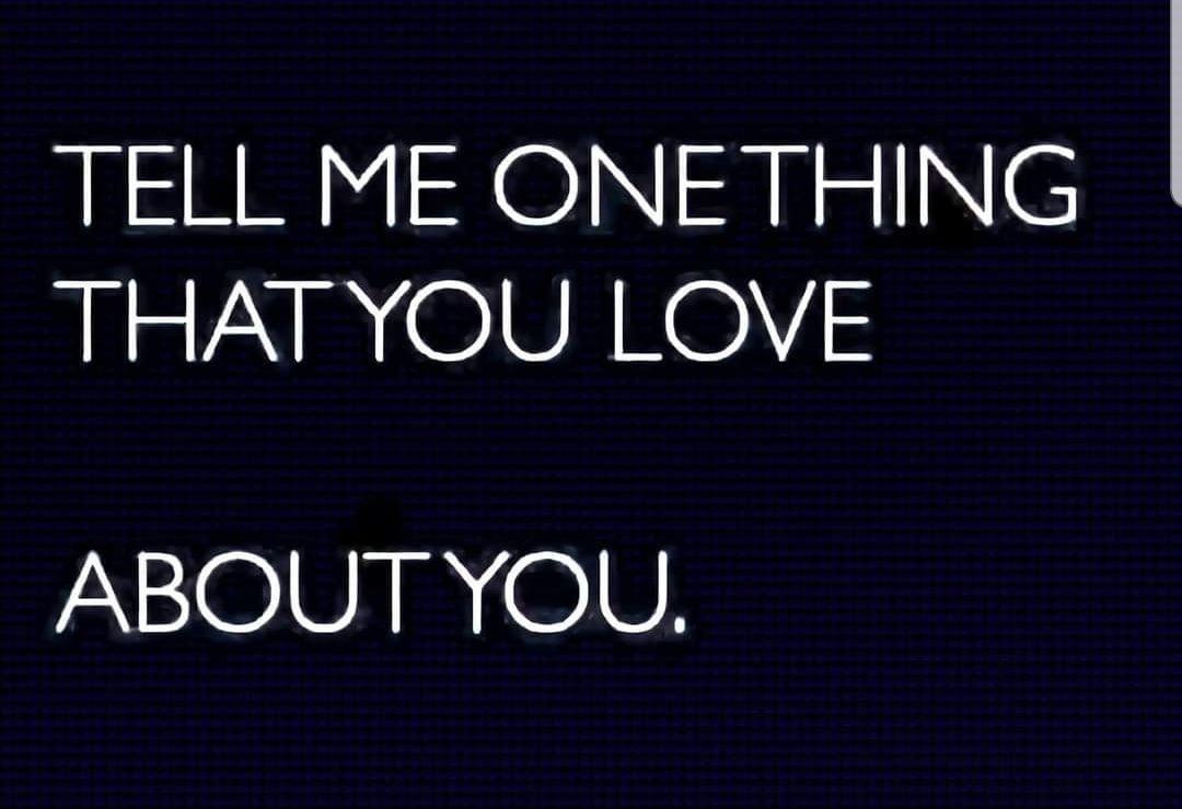 A dark background features bold, white text that reads, 'Tell me one thing that you love about you.' The text is centered and is designed in a clean, modern font, creating a striking visual impact.