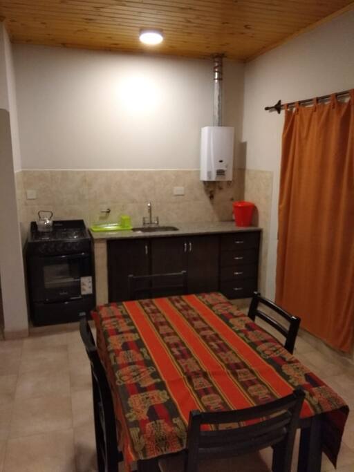 cocina comedor equipada con juego de vasos, platos, cubiertos, horno y heladera