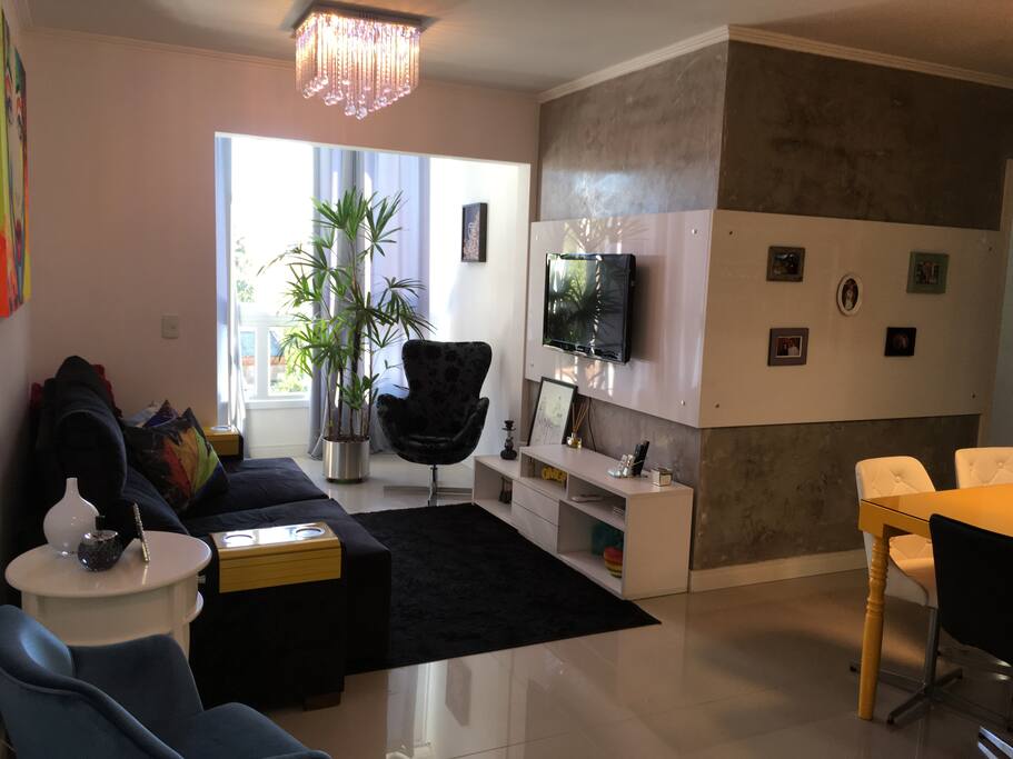 Sala decorada com sacada integrada e churrasqueira elétrica