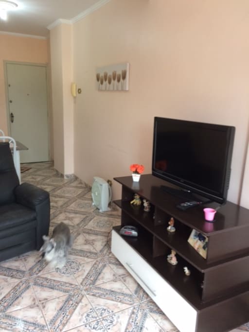 Sala com dois ambientes: de estar com sofá/cama para 2 pessoas + TV 42" e vista para o mar; sala de jantar acoplada à cozinha americana