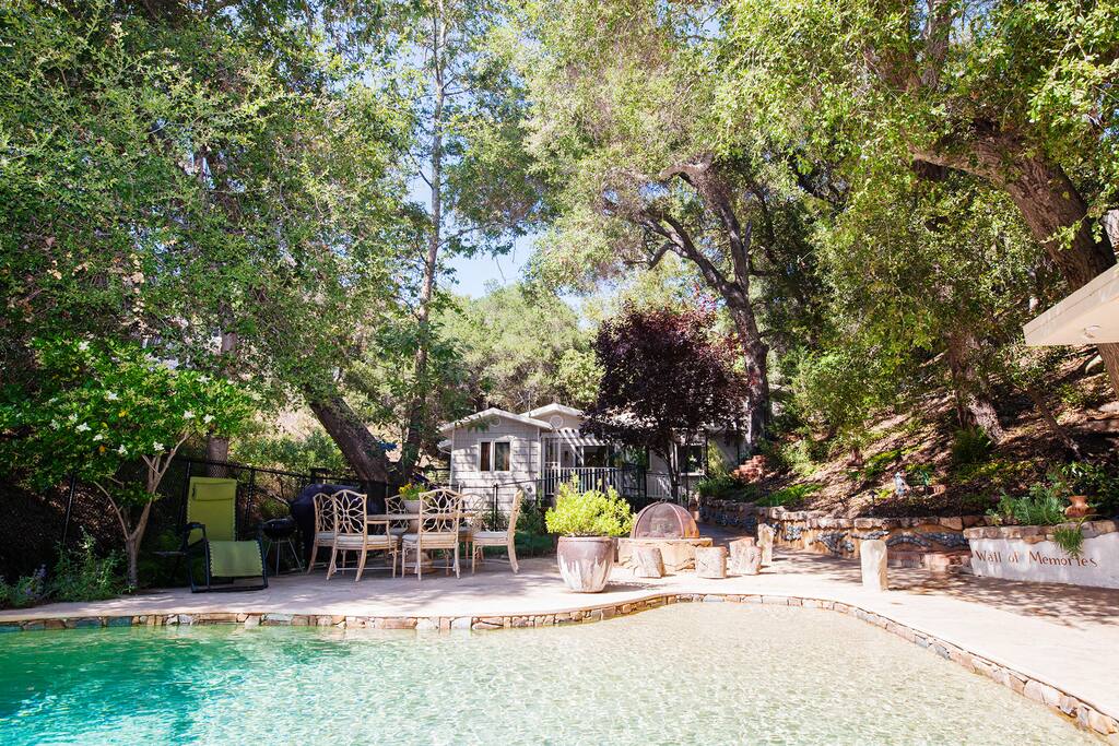 Natural chlorine-free pebble bottomed beach slopped swimming pool with waterfall