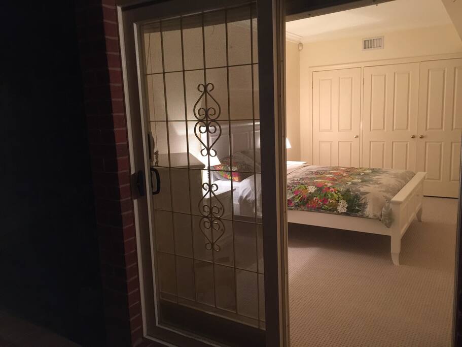 An airy master bedroom, which is well lit with natural light.