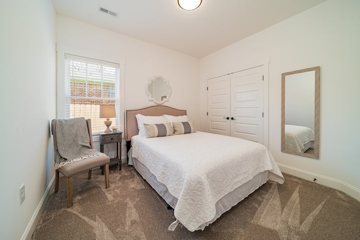 The Queen Room includes a large closet, accent chair, and nightstands. 