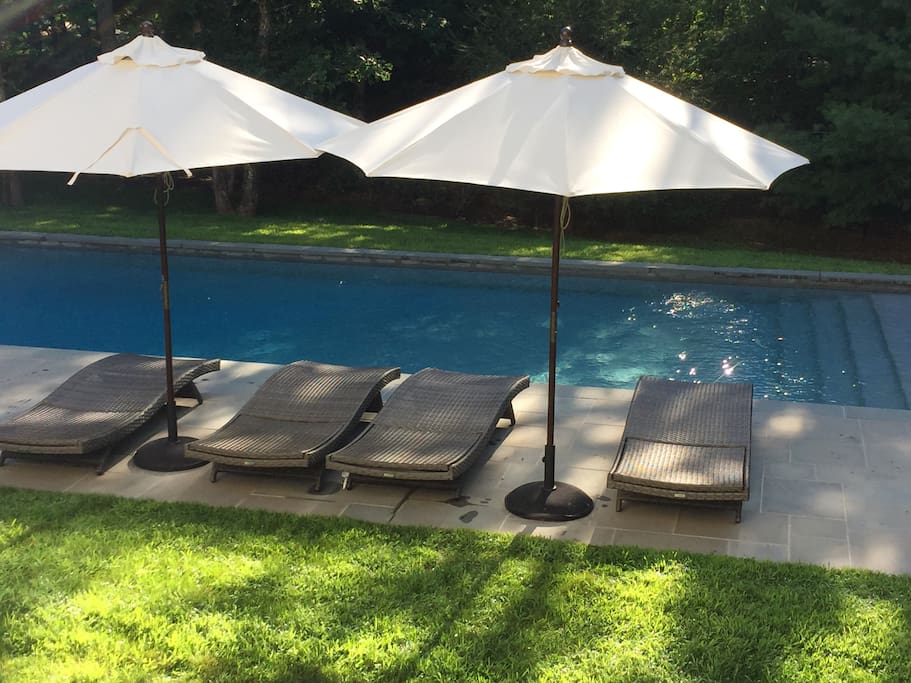 The expansive pool is luxurious with chairs with lounge chairs and umbrellas for a good time poolside.