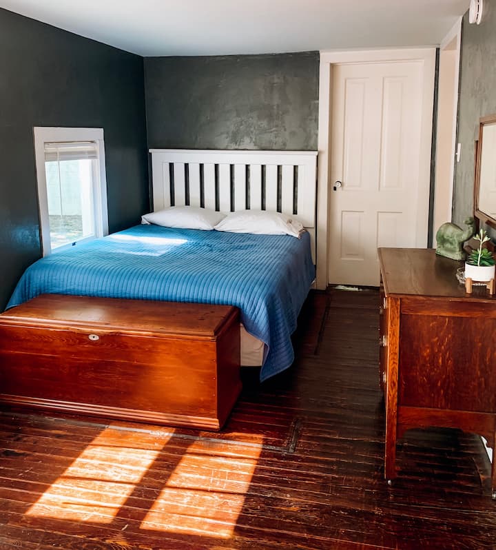 East Room - queen bed, dresser, reading chair and trunk. 
