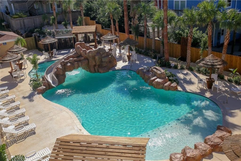 Resort pool with water slide and loungers