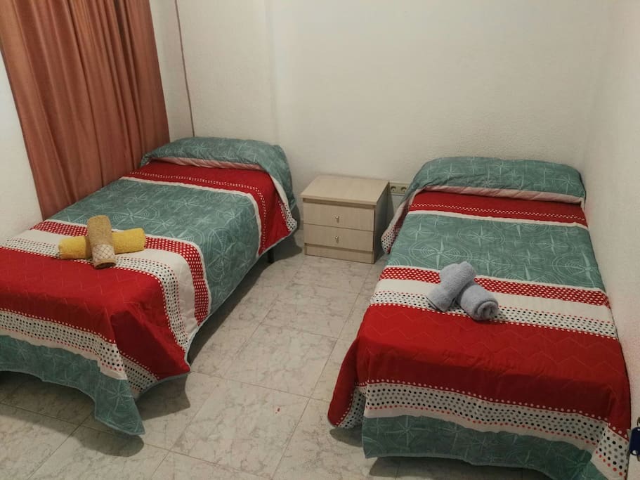 en la foto se muestra dos camas gemelas de 90 cm y una mesita de noche