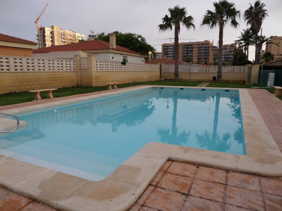 PISCINA CON ZONAS AJARDINADAS.