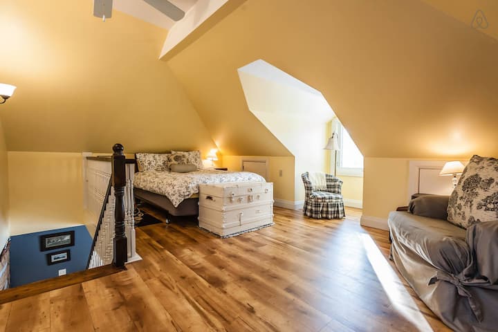 ห้องนอนแบบลอฟท์พร้อมเตียงควีนไซส์ในห้องใต้หลังคาของ Settler 