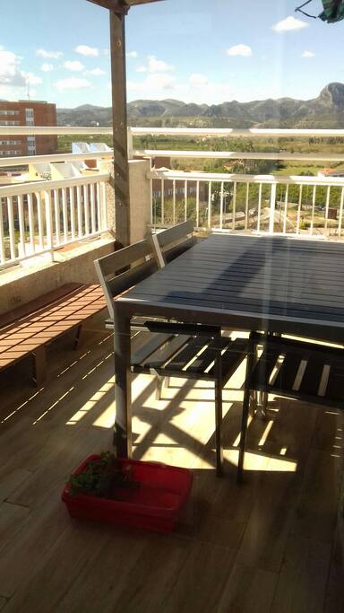 Terraza con pérgola de madera y toldo.