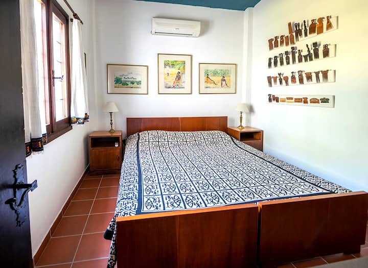 主卧配有两张单人床。 卧室装饰有传统的非洲艺术品和Nelly的绘画。