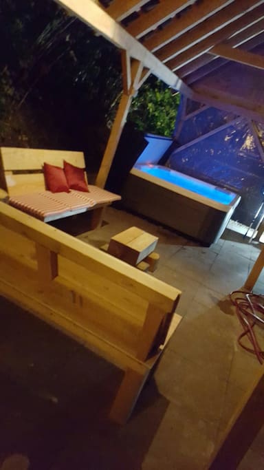 de houten bankjes en de jacuzzi bij avond