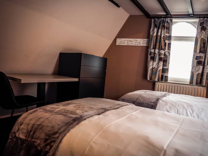 Twin beds top level room; writing desk; wardrobe