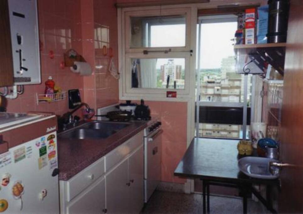 Esta es la cocina del departamento. Tiene una heladera del tamaño justo para las vacaciones, con un congelador. Realmente funciona muy bien.
Además del horno común, tiene un horno eléctrico muy práctico para calentar comidas rápidas.
En la alacena hay vajilla y todos los elementos necesarios, ya sean ollas CAPEA, cucharones, pava, fuentes, etc.
Por último, al fondo se puede ver el pequeño pero práctico lavadero al estilo balcón francés, con un cerramiento muy seguro, especialmente para los niños.
La vista de ese balcón da a TODA LA PEATONAL DE MIRAMAR y también a la calle 14 (1º desde la costa)