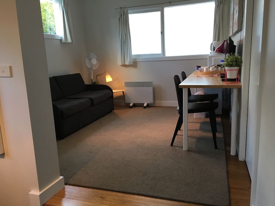 Top level of bungalow - sitting area, TV, small bar fridge, kettle, microwave, toaster, TV, heater, fan