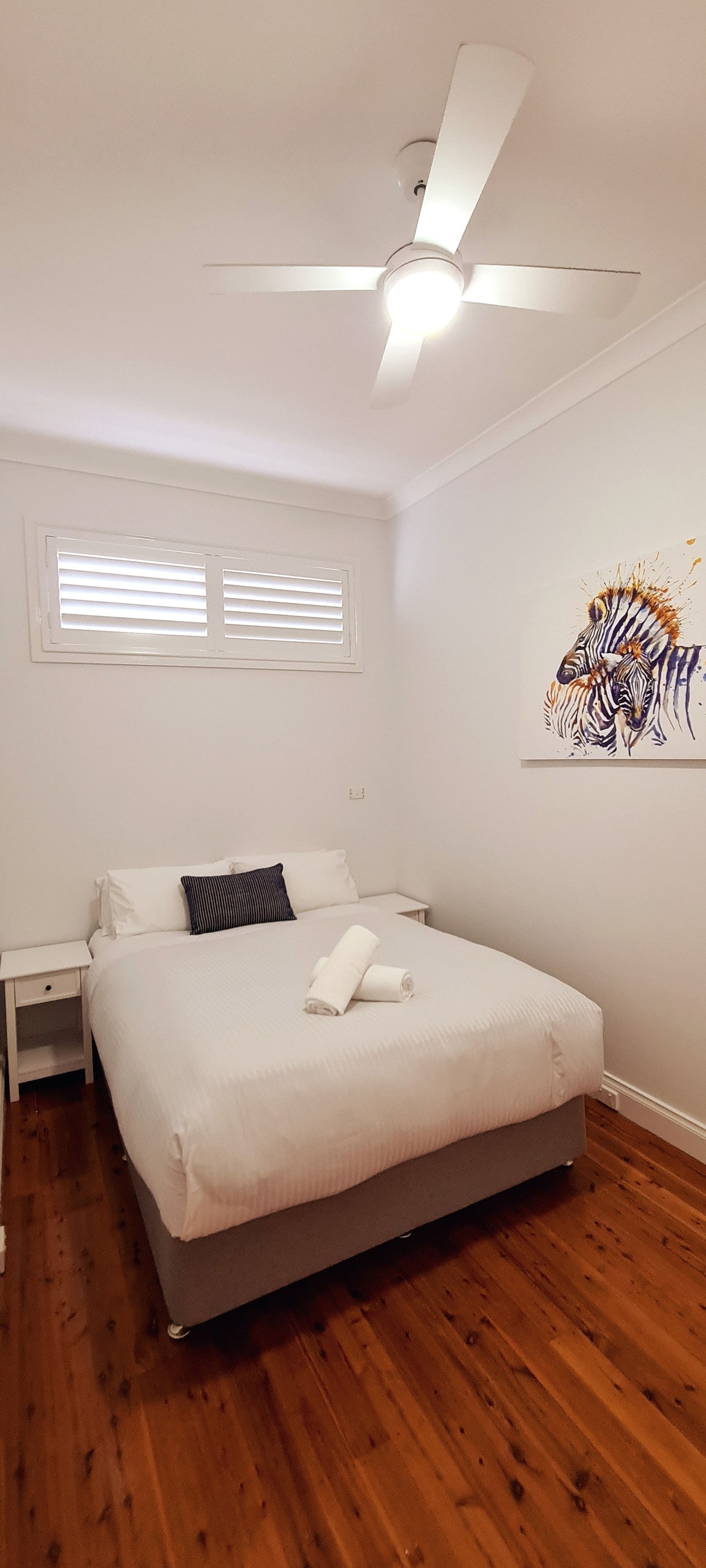 Spálňa s manželskou posteľou Queen a stropným ventilátorom a vstavaným šatníkom