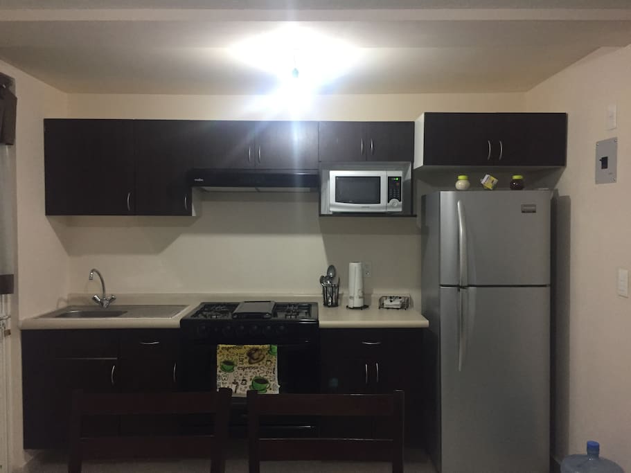 Cocina Integral con lo esencial para que puedas cocinar. Cuenta con microondas refrigerador estufa y horno.