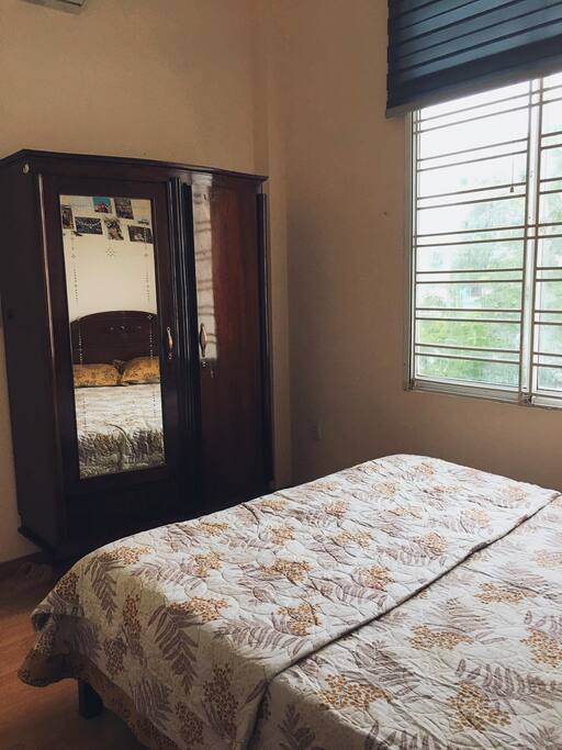 The room is equipped with a bed for two, a wardrobe, a chair and a coffee table