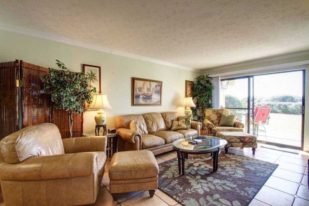 Gorgeous and Comfortable Living Area with Tons of Leather Seating, Abundant Florida Sunshine, Huge TV, & Custom Tile Throughout!