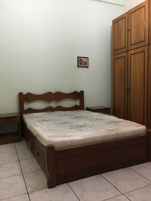 Quarto com cama de casal e armário, ventilador e ar condicionado
