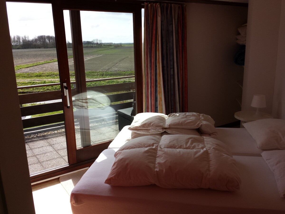 Dormitorio 1 con cama doble y balcón con asientos.