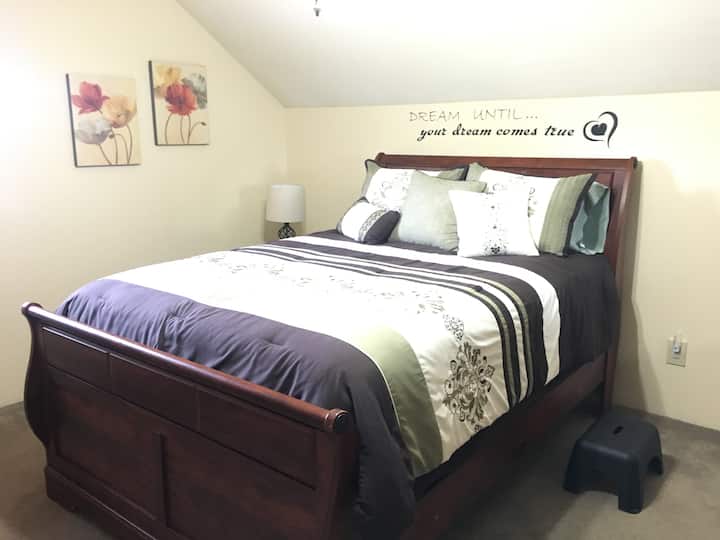 חדר שינה ראשי עם מיטת קווין סייז וארון תואם.