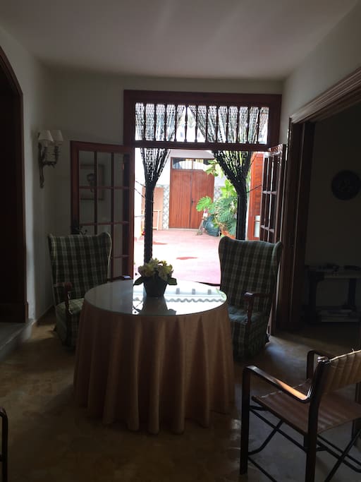 Foto desde la entrada de casa, a la derecha se ve un espacio abierto con un mueble bar y mesa de juegos y a la izquierda la sala de estar y enfrente tenemos el patio