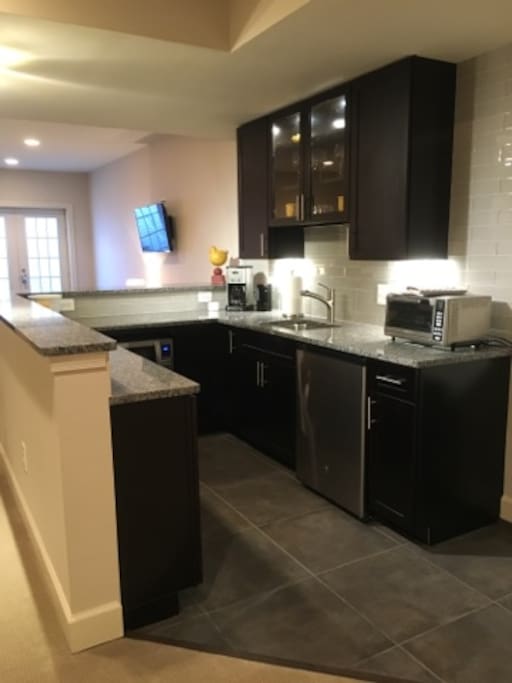 The kitchen includes refrigerator, microwave, convection toast oven, coffee machine and hot water boiler.