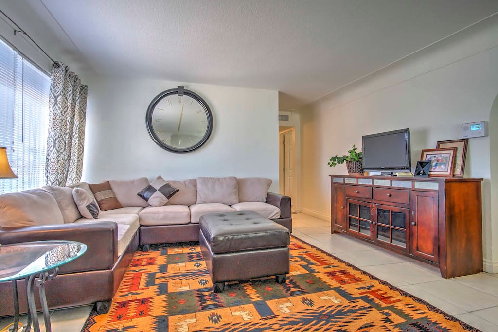 The living room features a comfortable wrap-around couch and a TV with local HD channels.
