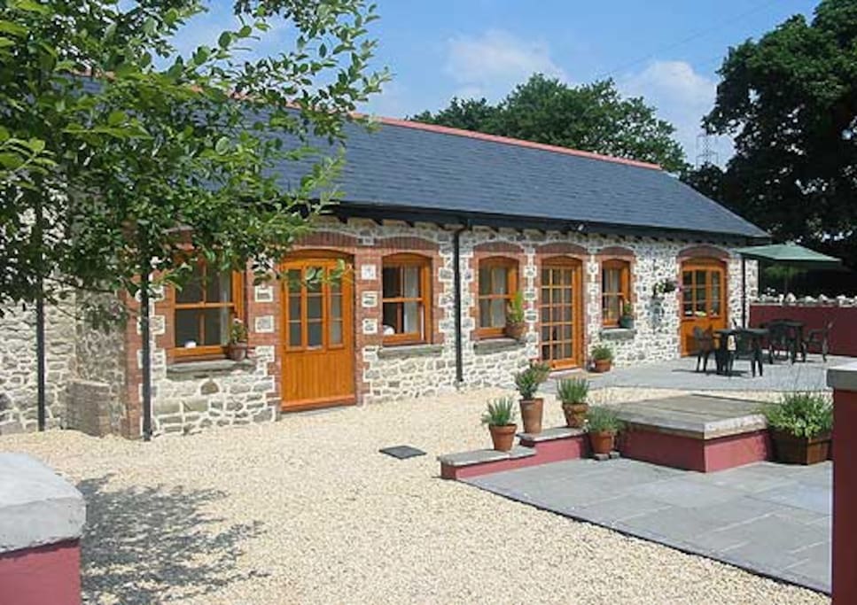 The sunny south facing patio leading into Kingfisher Cottage on the right and Swallow Cottage on the left.