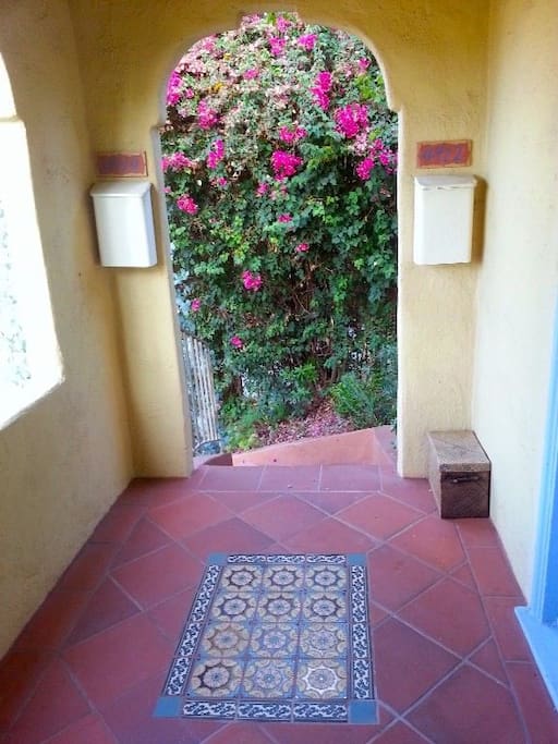 Enter through a Spanish tiled stairway drenched in bougainvillea