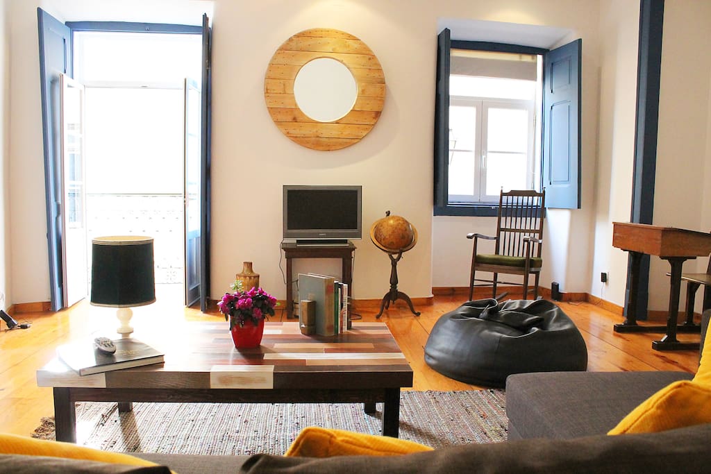 Living room with balcony and window facing the street.