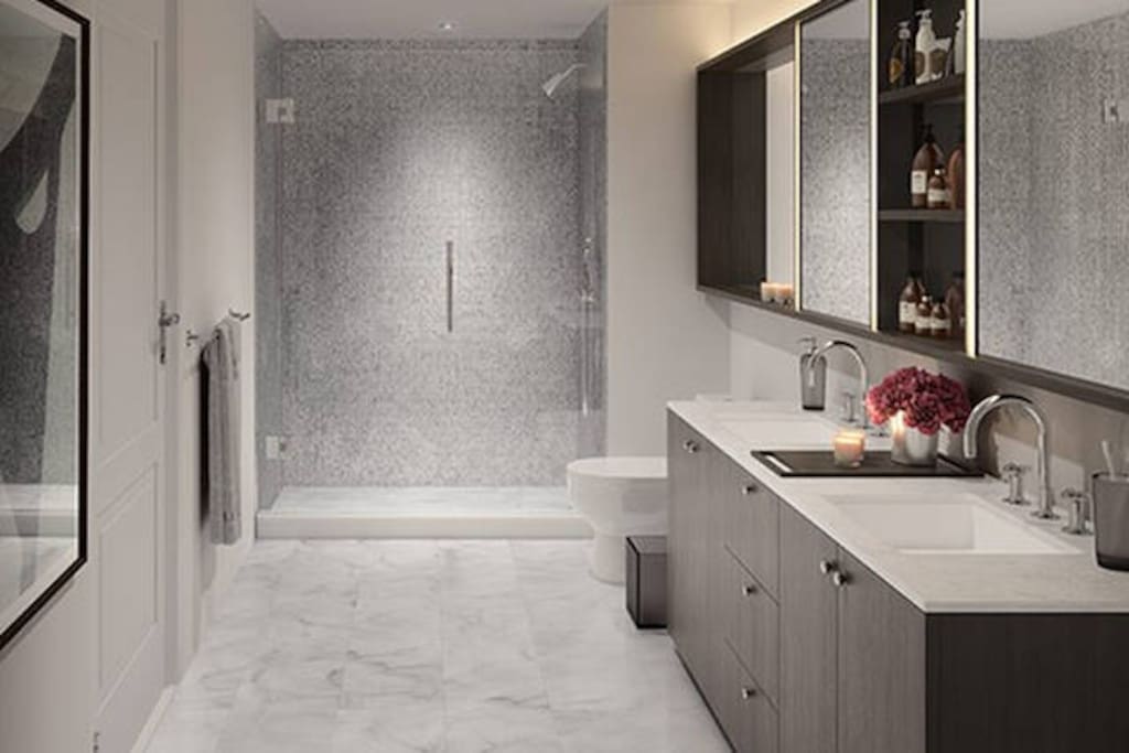 Custom oak bathroom cabinetry with polished chrome hardware, marble showers and double vanities