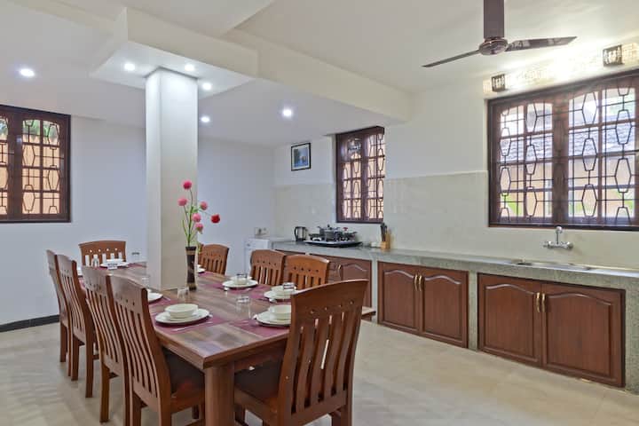 The dining room cum kitchen has a table with 10 chairs