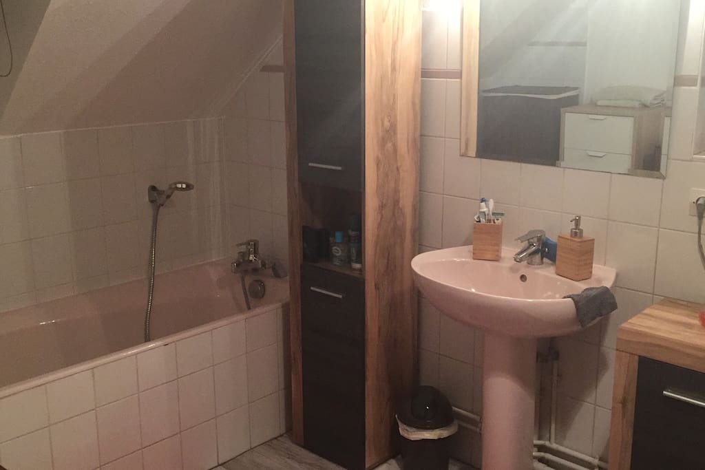 La salle de bain avec baignoire et lavabo