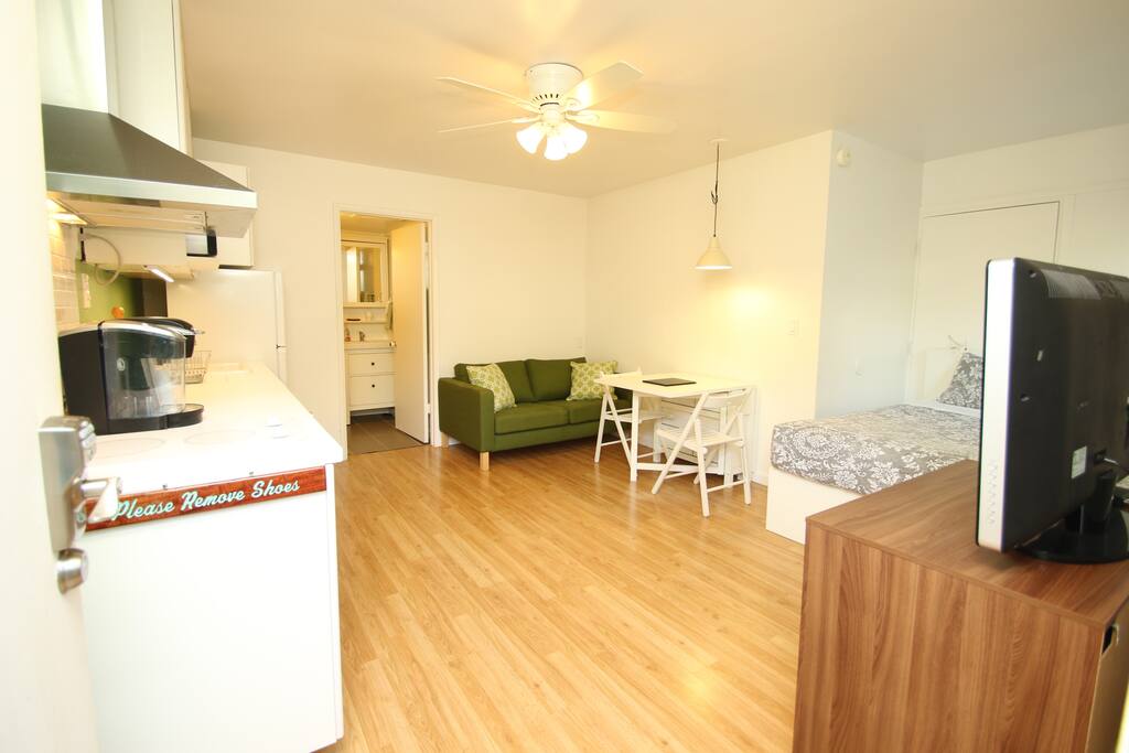 E komo Mai! Queen size bed, dining table and a sofa.