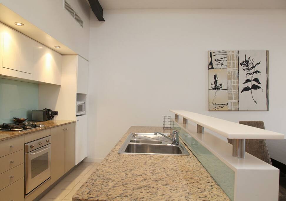 Fully-equipped domestic kitchen. Stone bench tops, gas stove, large fridge, dishwasher etc