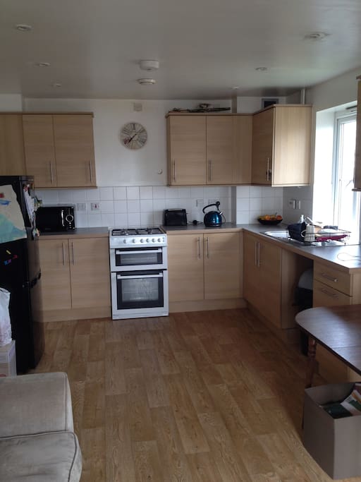 Kitchen with, refrigerator, dishwasher,microwave, kettle, cooker, toaster.