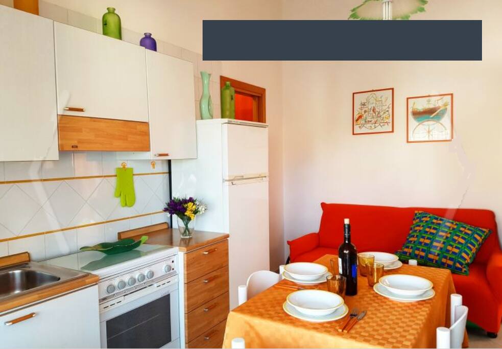 cucina soggiorno accessoriata con divano letto matrimoniale (2 posti letto) e accesso al balcone