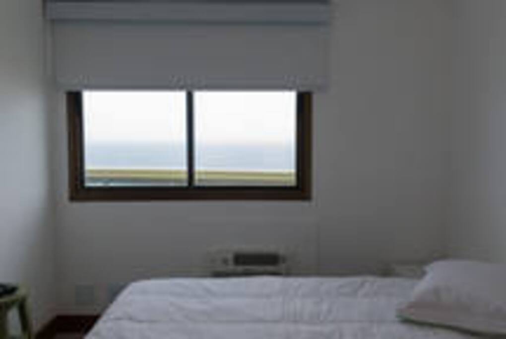 Quarto com cortina Rolô e cama Box casal, banco de apoio e cabeceiras e armário embutido com cabides