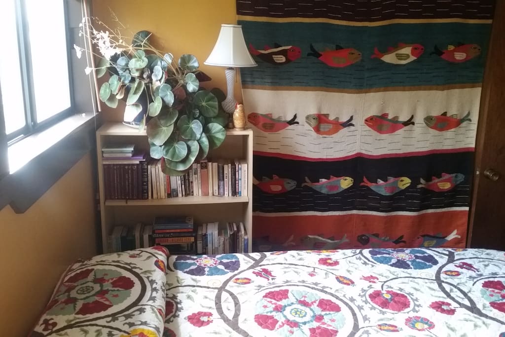 Plenty of books (classics and modern) and a fish tapestry to top it off