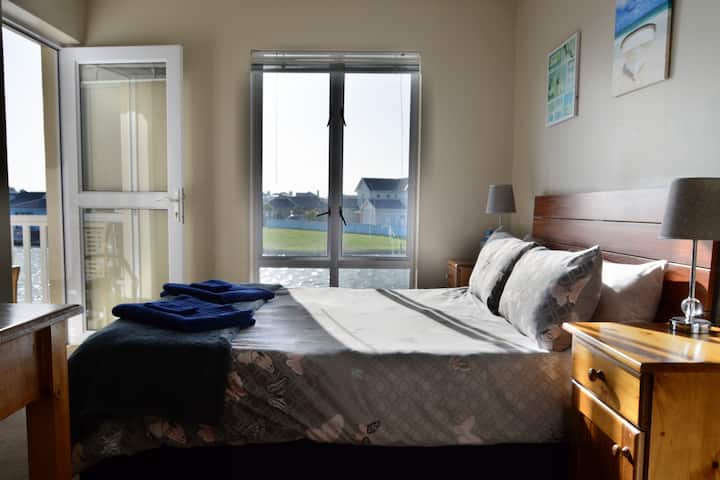 Main bedroom with door leading to the patio  overlooking the Marina for beautiful sunrise views!