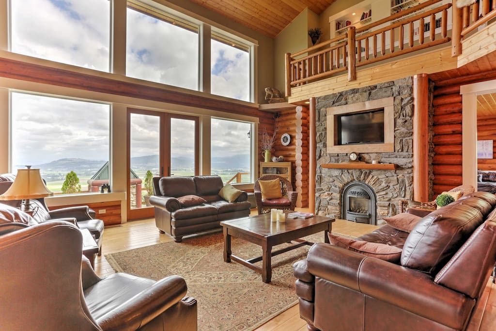 Relax in the family room that boasts floor-to-ceiling windows, cathedral ceilings, a stone, gas fireplace, plush leather furniture, and a flat-screen cable TV.