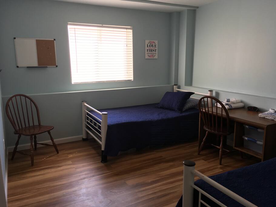 Bedroom features two twin beds with clean bedding. A pack and play available for young infants/toddlers.