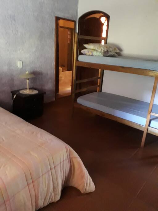 Suíte com cama de casal, beliche e armário amplo.