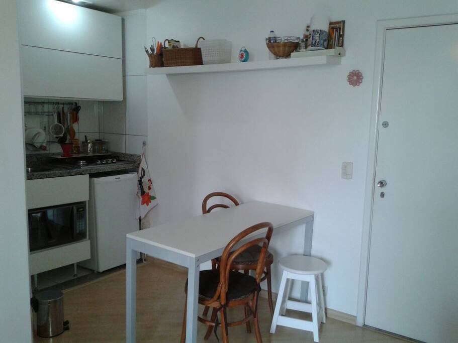Cozinha americana e mesa balcão para refeições.