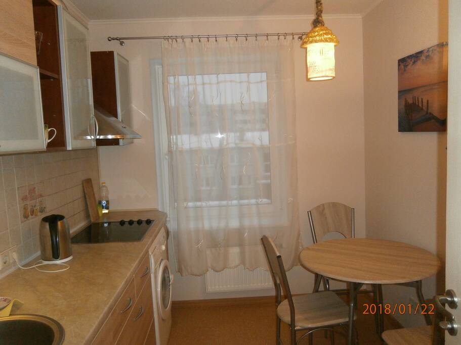 kitchen with washing machine, glass table and big fridge