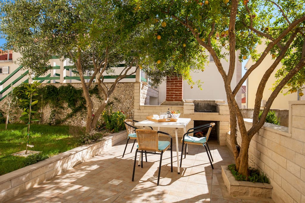 lovely terrace in greenery with dining table and BBQ