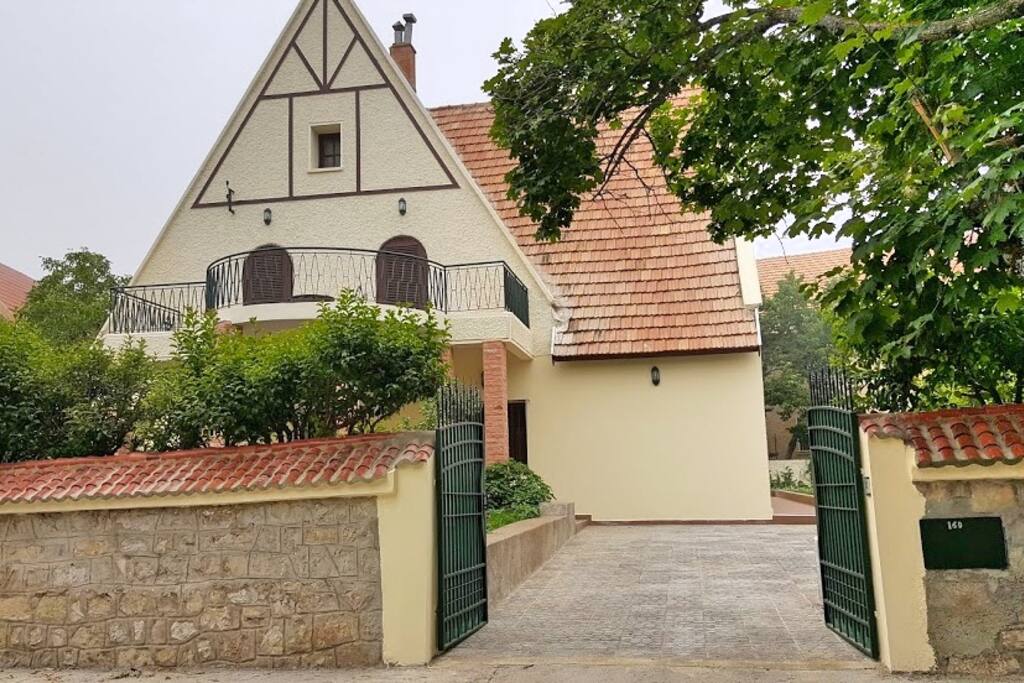 Vue sur la façade principale et porte ouverte de l'espace dédiée à deux voitures.